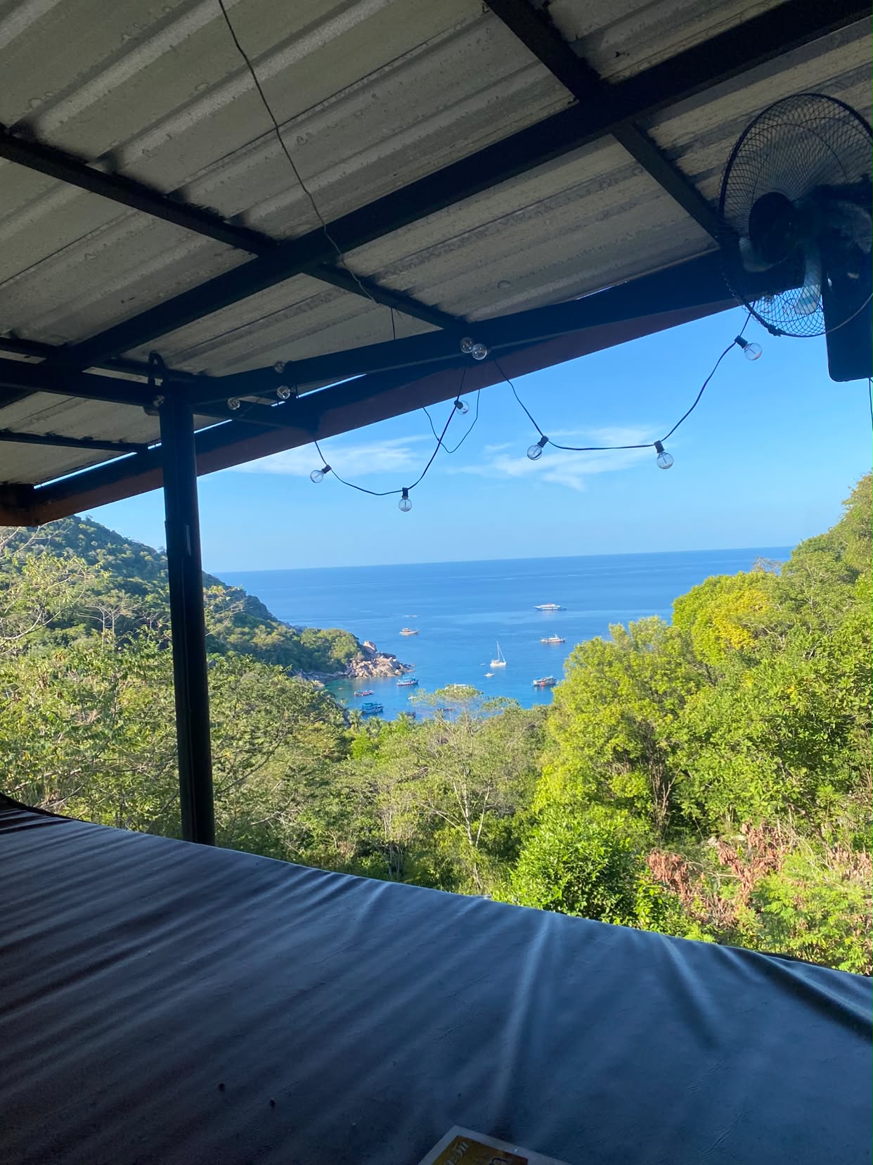 The view from a bunk bed at Hin Wong — the bay, boats and green ridge line
